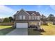 Charming two-story home with stone accents, a well-manicured lawn, and an attached two-car garage at 35 Wolf Ridge Ct, Willow Springs, NC 27592