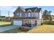 Two-story home features a covered front porch, a two-car garage, and manicured landscaping at 35 Wolf Ridge Ct, Willow Springs, NC 27592
