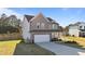 Two-story home boasts a covered front porch, a two-car garage, and a lush green lawn at 35 Wolf Ridge Ct, Willow Springs, NC 27592