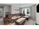 Comfortable living room featuring a luxurious leather sectional, plush ottoman, and large window at 35 Wolf Ridge Ct, Willow Springs, NC 27592