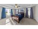 Sun-lit primary bedroom featuring tray ceilings, neutral walls, and three large windows at 35 Wolf Ridge Ct, Willow Springs, NC 27592