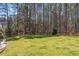 A large, grassy backyard surrounded by mature trees, offering ample space for recreation and outdoor activities at 3504 Griffice Mill Rd, Raleigh, NC 27610