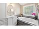 Relaxing bathroom with a soaking tub, white vanity, and a large window at 3504 Griffice Mill Rd, Raleigh, NC 27610