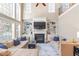 Spacious living room featuring a fireplace, built-in bookshelves, tall windows, and hardwood floors at 3504 Griffice Mill Rd, Raleigh, NC 27610