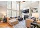 Bright living room featuring tall windows, a fireplace, built-in shelving and neutral toned couches at 3504 Griffice Mill Rd, Raleigh, NC 27610
