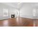 Cozy living room features hardwood floors, large windows and fireplace with white mantel at 4005 Freesia Ct, Zebulon, NC 27597