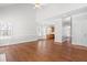 Bright living room with hardwood floors and natural light from large windows overlooking front yard at 4005 Freesia Ct, Zebulon, NC 27597