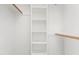 Bright walk-in closet with white shelving and wooden closet rods at 4005 Freesia Ct, Zebulon, NC 27597