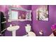 Eclectic powder room with purple walls, decorative mirror and fixtures at 417 Sapphire Rd, Burlington, NC 27215