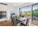 Dining room featuring a dark wood table, gray chairs, and sliding doors to a balcony with wooded view at 4720 Cypress Tree Ln, Raleigh, NC 27612