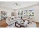 Bright living room with two sofas, a dark coffee table, ceiling fan, and an array of windows at 4720 Cypress Tree Ln, Raleigh, NC 27612