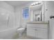 Bright bathroom features a tub-shower combination, toilet, and vanity with a large mirror and white cabinetry at 48 Delmar Ct, Fuquay Varina, NC 27526