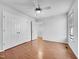 Spacious bedroom featuring hardwood floors, white walls, ceiling fan, window, and double closets at 48 Delmar Ct, Fuquay Varina, NC 27526