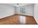 Bright bedroom with hardwood floors, large window, and ceiling fan, offering a comfortable living space at 48 Delmar Ct, Fuquay Varina, NC 27526