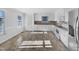 White kitchen with neutral countertops, stainless steel refrigerator, and sunlit window at 48 Delmar Ct, Fuquay Varina, NC 27526