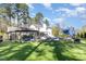 The backyard features a luscious lawn, an in-ground pool, an outdoor kitchen, and an umbrella-shaded dining area at 509 Queensferry Rd, Cary, NC 27511