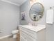 Elegant bathroom with a white vanity, round mirror, and modern lighting fixtures at 509 Queensferry Rd, Cary, NC 27511