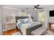 Bright bedroom featuring a dark wood bed frame, bench, and natural light from two windows at 509 Queensferry Rd, Cary, NC 27511