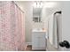 Bright bathroom featuring a vanity, mirror, shower with patterned curtain, and towel rack at 513 S Cheatham St, Franklinton, NC 27525