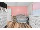 Pink-walled Bedroom featuring a crib, white dresser and vinyl floors at 513 S Cheatham St, Franklinton, NC 27525
