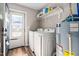 Functional laundry room with washer, dryer, water heater, and back door access at 513 S Cheatham St, Franklinton, NC 27525