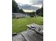 Backyard with tiki torches, a picnic table set for dinner, and a grill at 529 Flanagan Rd, Henderson, NC 27537