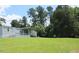 Exterior view of the home showcasing the spacious yard and surrounding mature trees at 529 Flanagan Rd, Henderson, NC 27537