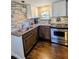 Bright kitchen with tile backsplash, granite counters, stainless appliances, and hardwood flooring at 529 Flanagan Rd, Henderson, NC 27537