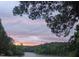 Beautiful sunset view of the lake surrounded by lush trees, a serene and peaceful landscape at 529 Flanagan Rd, Henderson, NC 27537