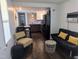 Cozy living room with hardwood floors, a black futon, and an open concept kitchen at 529 Flanagan Rd, Henderson, NC 27537