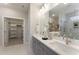 Bathroom featuring double sinks, large mirror, white marble floors, walk-in shower, and a walk-in closet at 604 Whistable Ave, Wake Forest, NC 27587