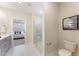 Bathroom featuring gray cabinets, marble floors, glass shower and a peek of the staged primary bedroom at 604 Whistable Ave, Wake Forest, NC 27587