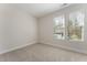 A bright bedroom has neutral carpet, white walls, and two windows with blinds at 604 Whistable Ave, Wake Forest, NC 27587
