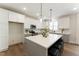 Well-lit kitchen features white cabinets, stainless steel appliances, and a large center island with seating at 604 Whistable Ave, Wake Forest, NC 27587