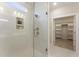 Walk-in shower with glass door, tile walls and floor, niche and rain shower head; walk-in closet in background at 604 Whistable Ave, Wake Forest, NC 27587