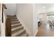 Staircase with carpeted steps and white trim, leading to the second floor and a view of the kitchen area at 604 Whistable Ave, Wake Forest, NC 27587