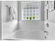 Bright bathroom features a tiled tub with plants on the window ledge at 627 Nixon Dr, Sanford, NC 27330