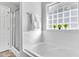 Bright bathroom features a tiled tub with glass block window and shower door at 627 Nixon Dr, Sanford, NC 27330