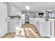 Bright kitchen area with white cabinets and view to the living area at 627 Nixon Dr, Sanford, NC 27330