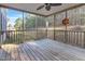 Spacious screened porch has wood floors, railings, ceiling fan and wooded views at 627 Nixon Dr, Sanford, NC 27330