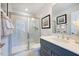Modern bathroom featuring a glass-enclosed shower, gray vanity with white countertop, and neutral-toned tile at 664 Sun Meadow Dr, Wake Forest, NC 27587