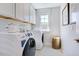 Convenient laundry room with white washer and dryer and storage cabinets at 664 Sun Meadow Dr, Wake Forest, NC 27587