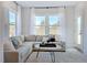 Cozy living room featuring a comfortable sectional sofa, large windows, and stylish decor at 664 Sun Meadow Dr, Wake Forest, NC 27587
