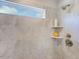 Tiled shower featuring a window, shower head, shampoo and soap niche, and brushed nickel fixtures at 664 Sun Meadow Dr, Wake Forest, NC 27587