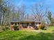 Charming single-story brick home with a covered front porch and mature landscaping at 707 Dickens St, Roxboro, NC 27573