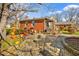 An inviting stone patio area features outdoor seating, a grill, and charming landscaping in the backyard at 712 Springwood Ave, Gibsonville, NC 27249