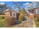 Charming backyard view with brick outbuilding, stone pathway, and manicured shrubs at 712 Springwood Ave, Gibsonville, NC 27249