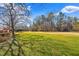 Expansive backyard with a mix of green grass and shade trees, perfect for outdoor activities at 712 Springwood Ave, Gibsonville, NC 27249