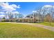 Charming brick home with a bright yellow front door and manicured landscaping on a large lot at 712 Springwood Ave, Gibsonville, NC 27249