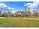 Charming brick home with well-manicured lawn and mature trees on a sunny day at 712 Springwood Ave, Gibsonville, NC 27249